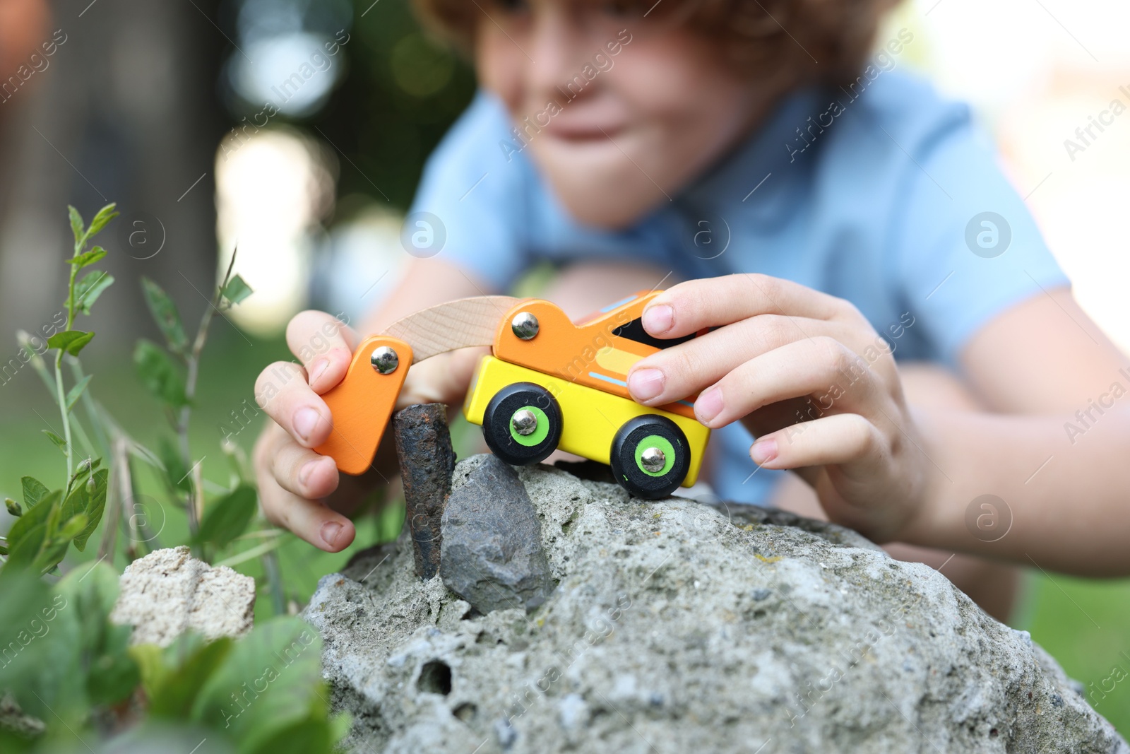 Little boy playing with toy car outdoors, selective focus Photo of Little boy playing with toy car outdoors, selective focus