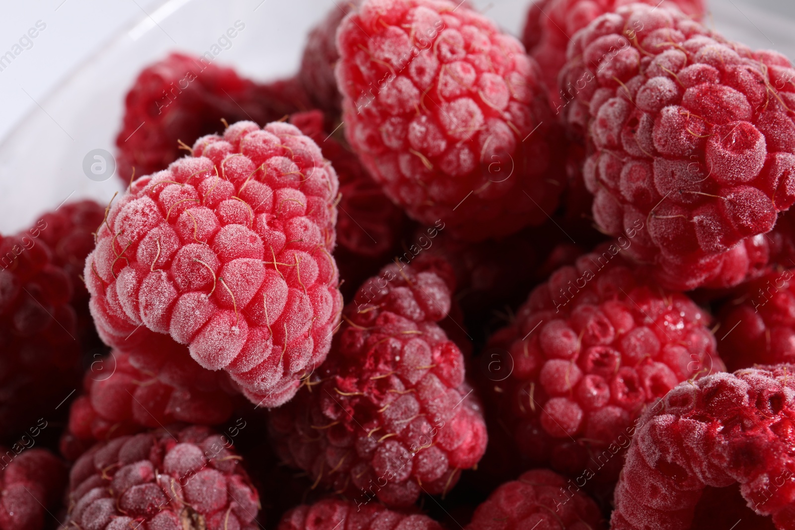 Photo of Many ripe frozen raspberries on light background, closeup