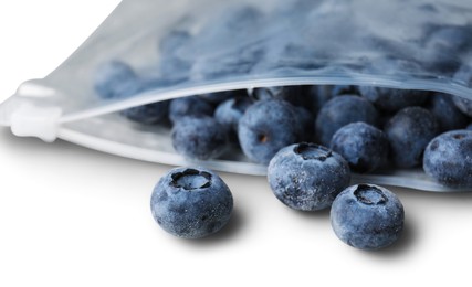 Photo of Ripe frozen blueberries in open zipper bag on white background, closeup