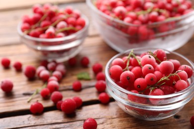 Photo of Ripe frozen red currants on wooden table, closeup