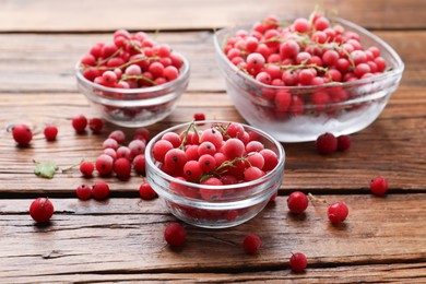 Photo of Ripe frozen red currants on wooden table, closeup