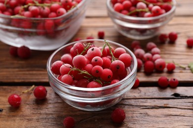 Photo of Ripe frozen red currants on wooden table, closeup