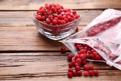 Photo of Ripe frozen red currants on wooden table, closeup