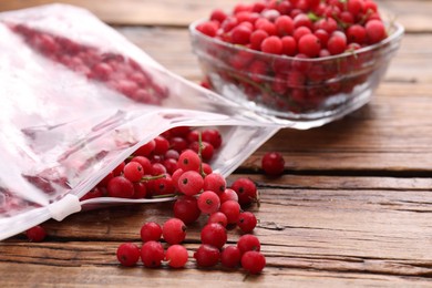 Photo of Ripe frozen red currants on wooden table, closeup