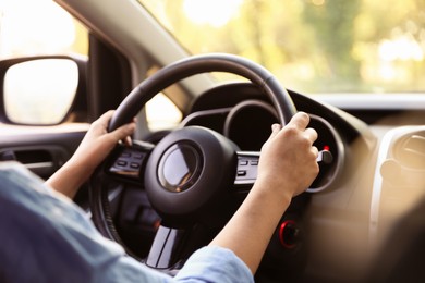 Photo of Woman behind steering wheel of modern car, closeup