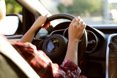 Photo of Woman behind steering wheel of modern car, closeup