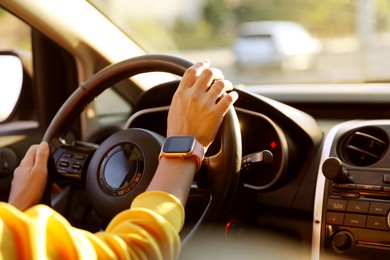 Photo of Woman behind steering wheel of modern car, closeup