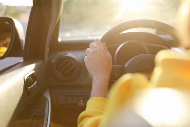 Photo of Woman behind steering wheel of modern car on sunny day, closeup