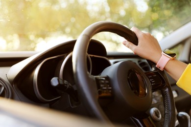 Photo of Woman behind steering wheel of modern car, closeup