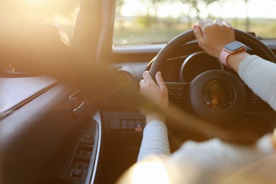 Photo of Woman behind steering wheel of modern car on sunny day, closeup