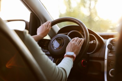 Photo of Woman behind steering wheel of modern car, closeup