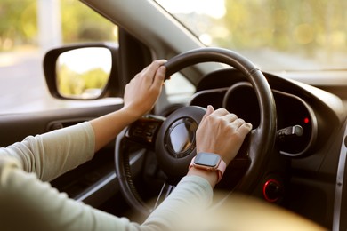 Photo of Woman behind steering wheel of modern car, closeup
