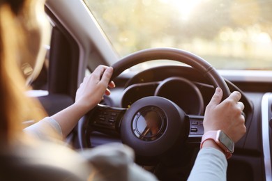 Photo of Woman behind steering wheel of modern car, closeup
