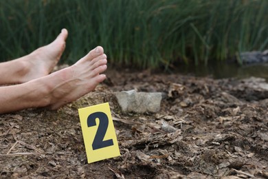 Photo of Forensic expertise. Crime scene with dead man's body and marker outdoors, closeup. Space for text