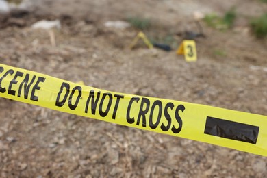 Photo of Forensic expertise. Crime scene with evidence and police tape outdoors, closeup