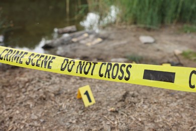 Photo of Forensic expertise. Crime scene with evidence and police tape outdoors, closeup