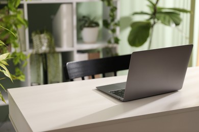 Photo of Biophilic interior design. Stylish workplace with laptop and houseplants in office