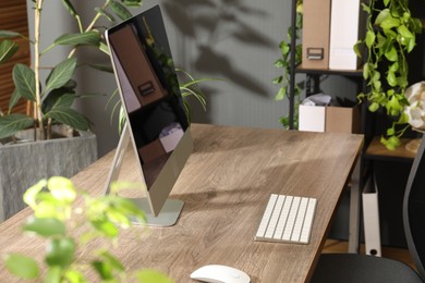 Photo of Biophilic interior design. Stylish workplace with computer and houseplants in office