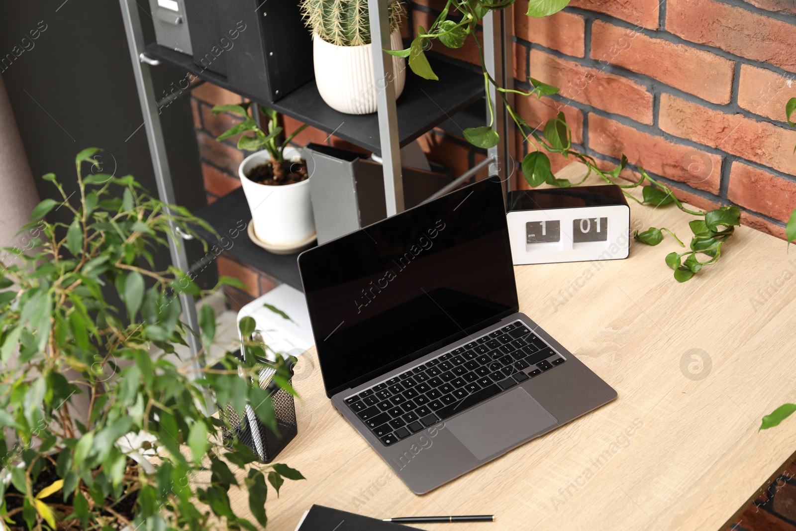 Stylish workplace with laptop, stationery and floral decor in office, above view. Biophilic interior design Photo of Stylish workplace with laptop, stationery and floral decor in office, above view. Biophilic interior design