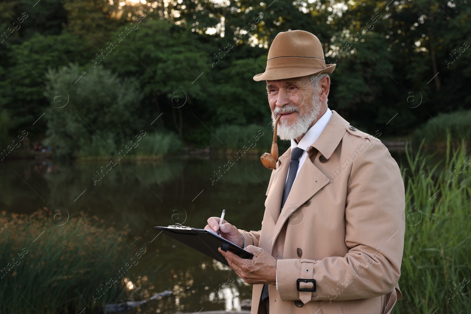 Photo of Forensic expertise. Detective with smoking pipe and clipboard working at crime scene near lake outdoors, space for text