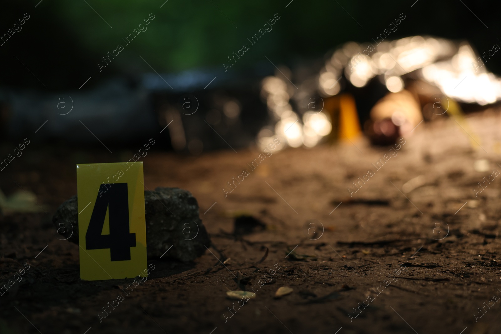 Photo of Forensic expertise. Crime scene with dead man's body outdoors, focus on marker