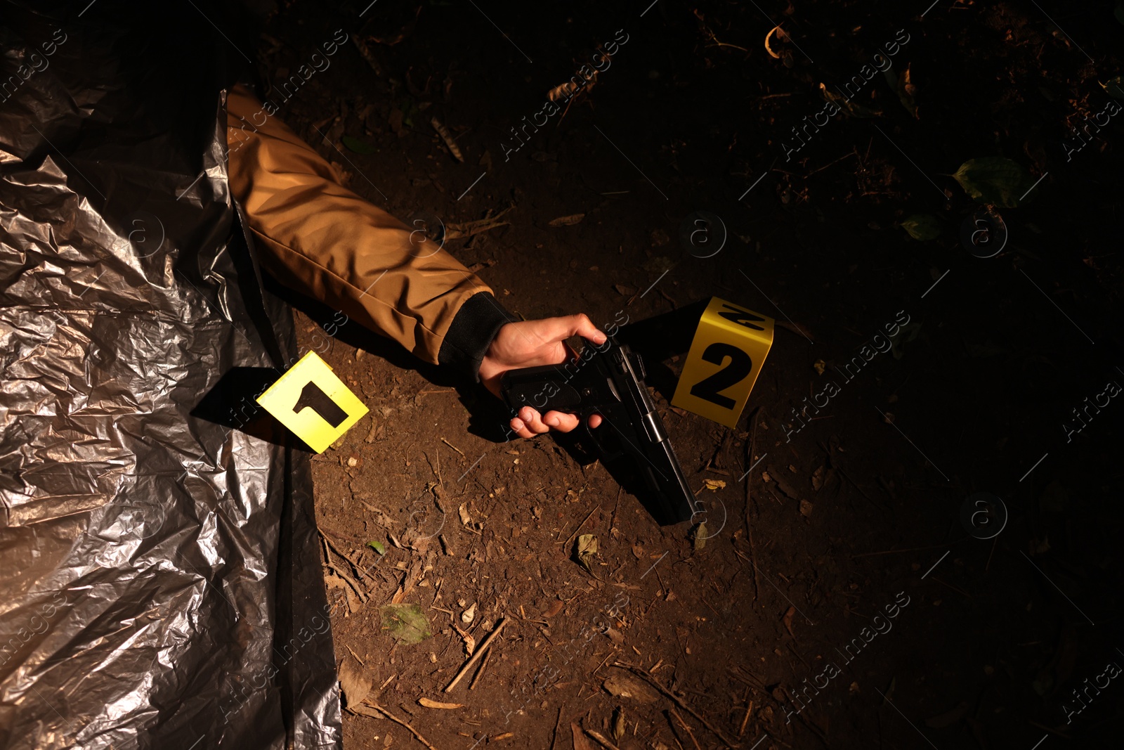 Photo of Forensic expertise. Crime scene with dead man's body, evidence and markers outdoors, above view
