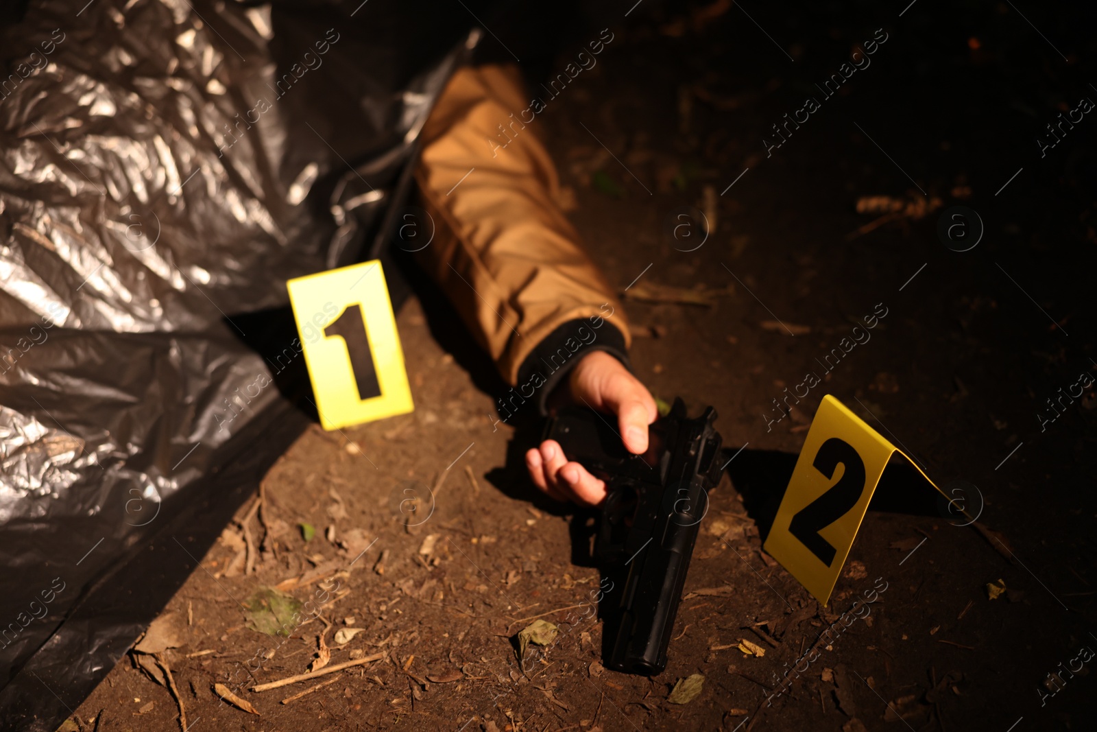 Photo of Forensic expertise. Crime scene with dead man's body, evidence and markers outdoors, closeup