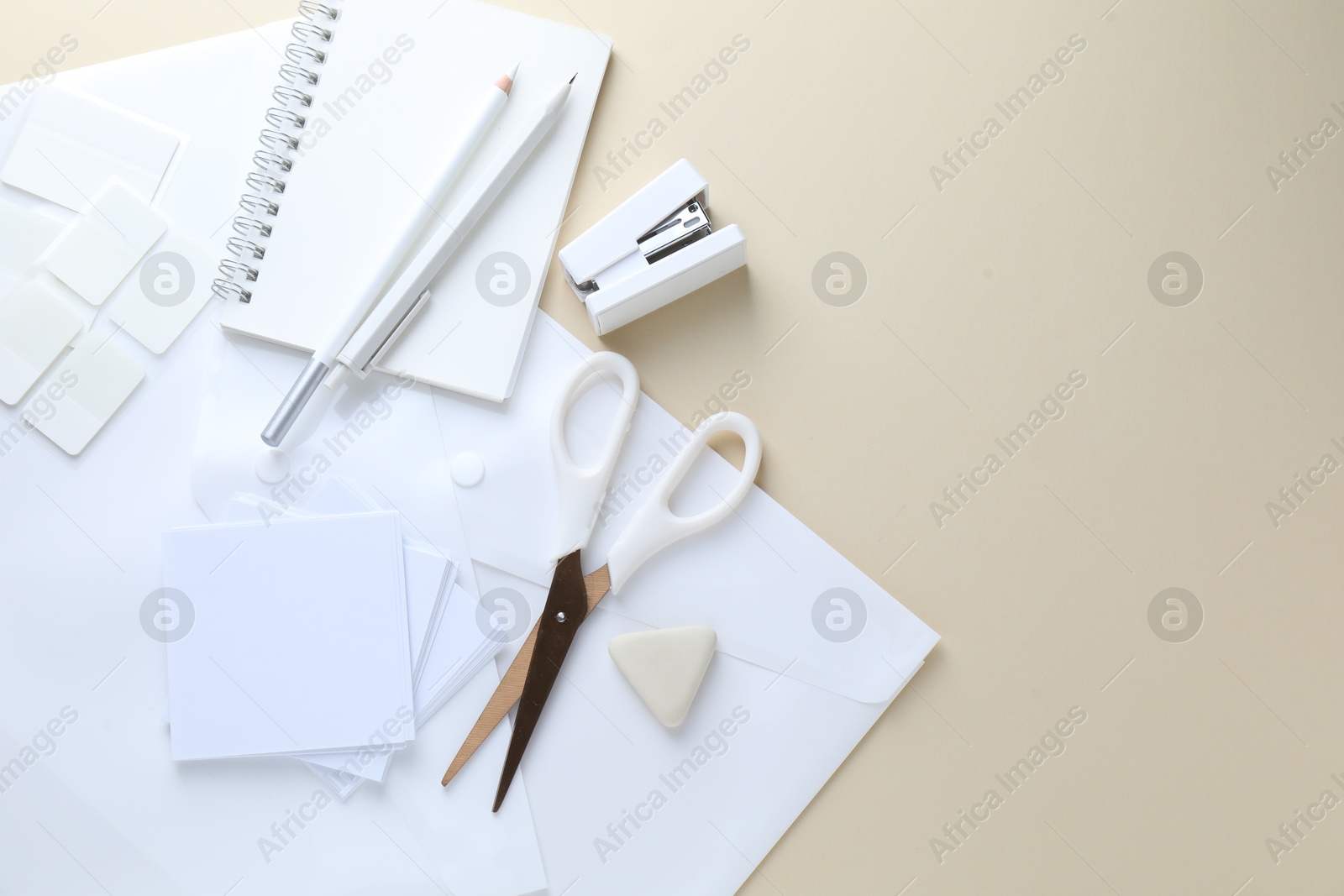 Photo of White stationery on beige background, flat lay. Space for text