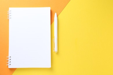 Photo of White notebook and pen on color background, flat lay. Space for text