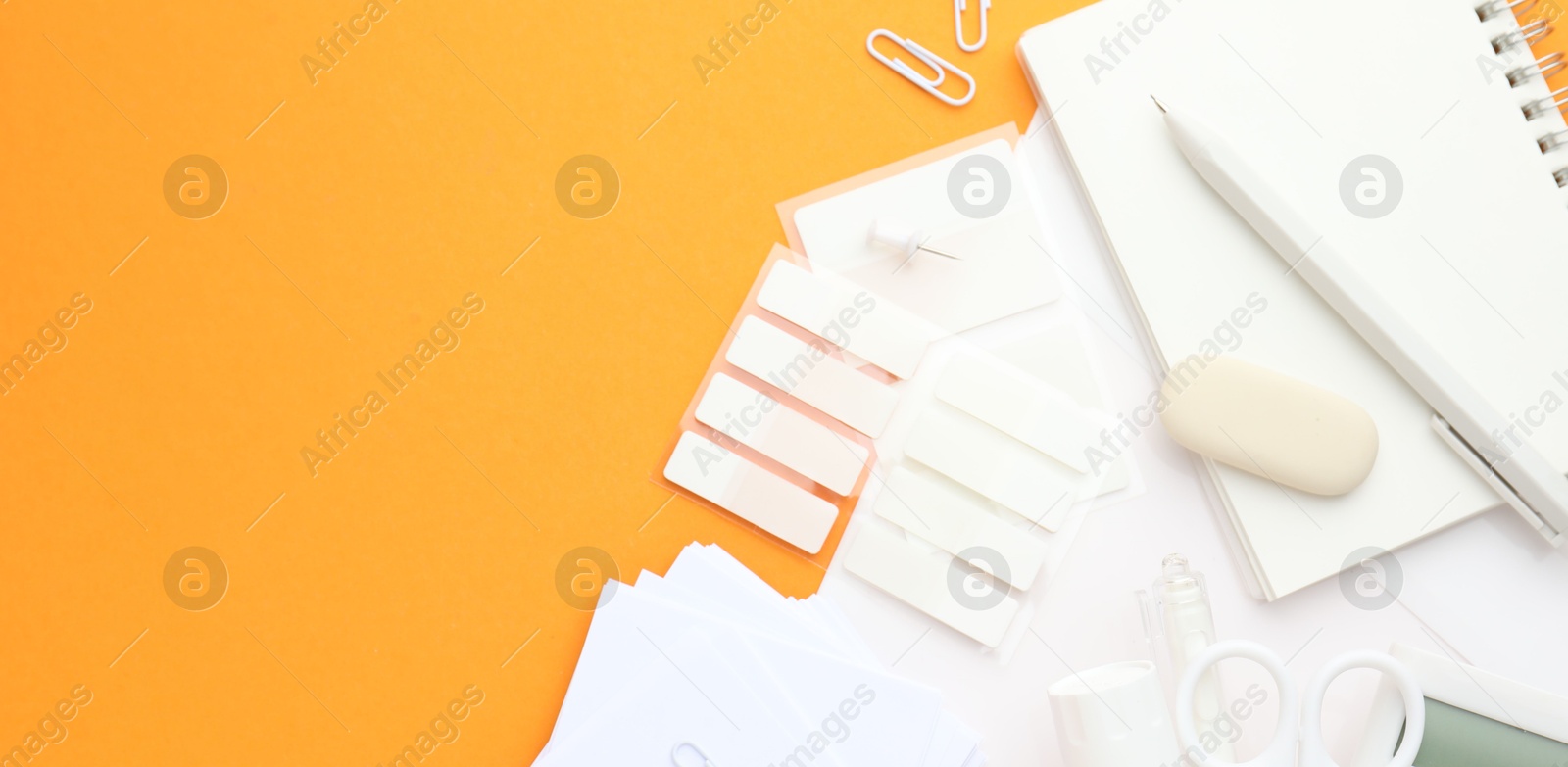 Photo of White stationery on orange background, flat lay. Banner design with space for text