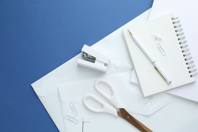 Photo of White stationery on blue background, flat lay. Space for text
