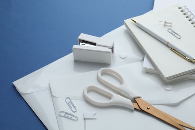 Photo of Stationery in white color on blue background, closeup