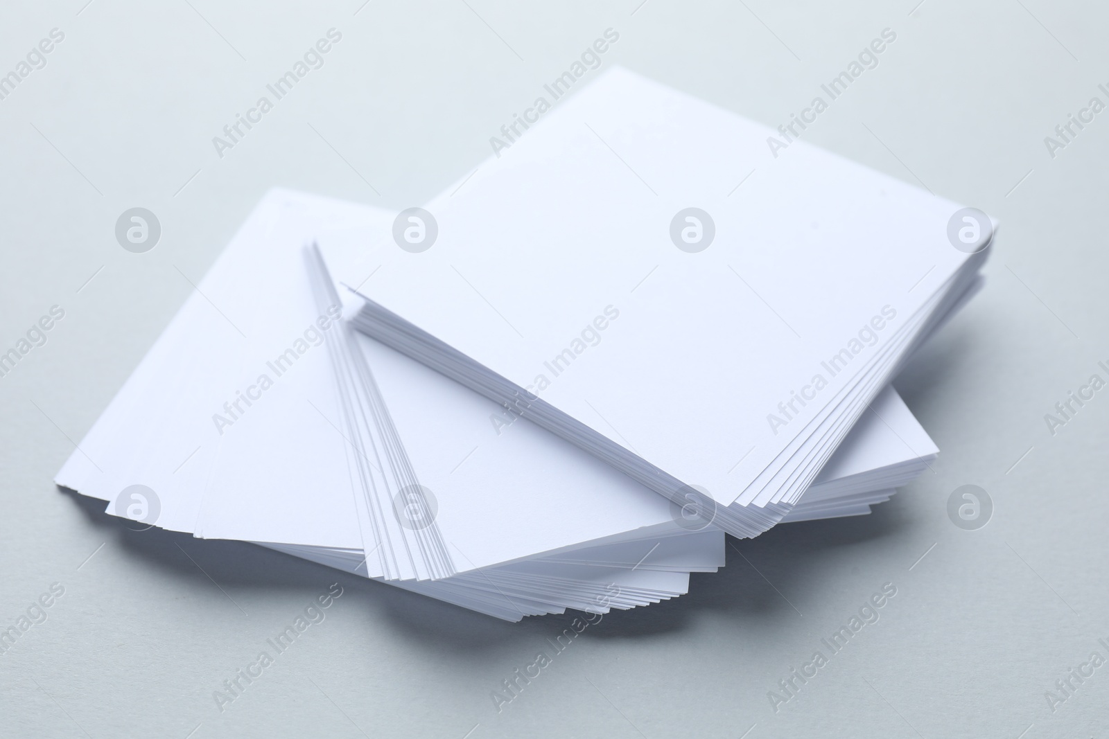 Photo of White note papers on light grey background, closeup