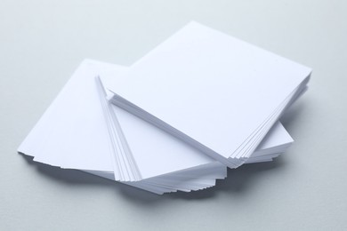 Photo of White note papers on light grey background, closeup