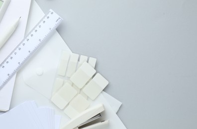 Photo of White stationery on light grey background, flat lay. Space for text