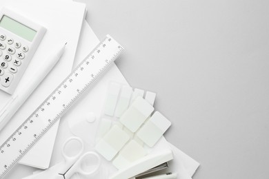 Photo of White stationery on light grey background, flat lay. Space for text