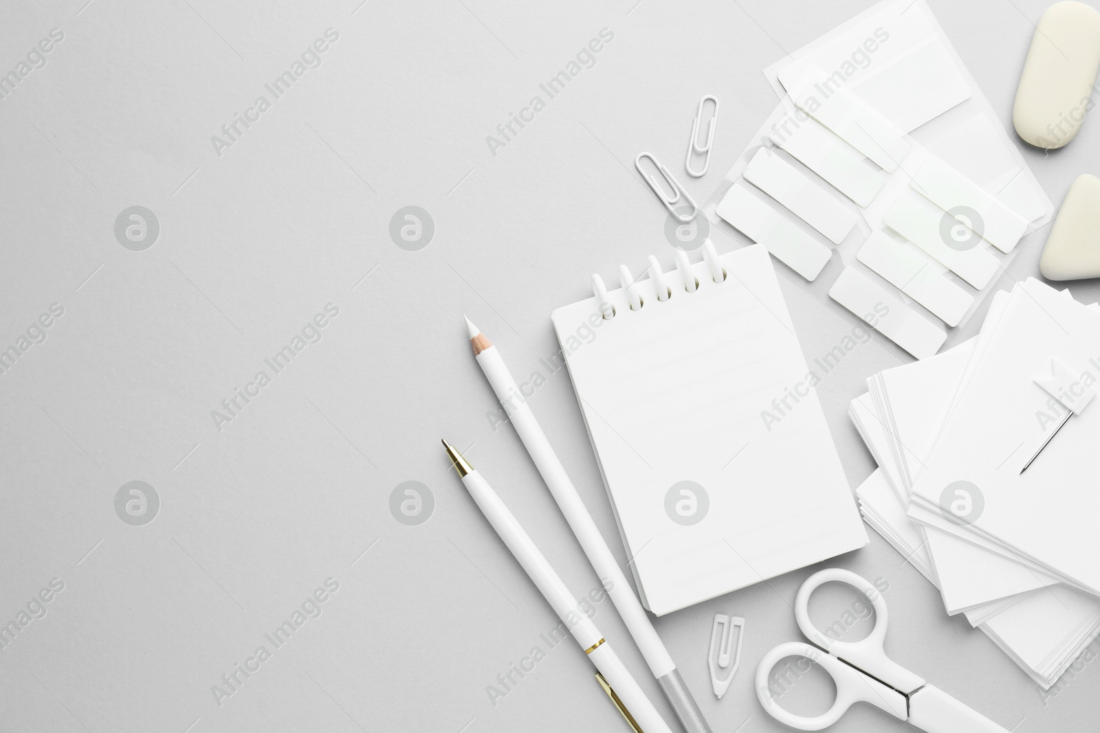 Photo of White stationery on light grey background, flat lay. Space for text