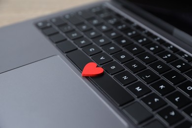 Photo of Online dating site. Red heart on laptop, closeup