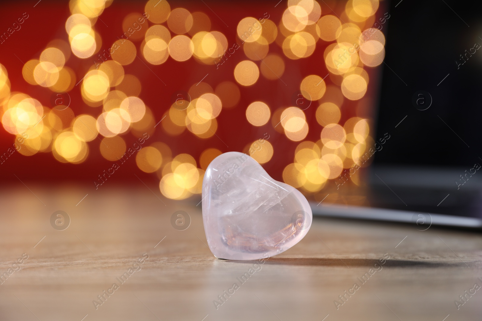 Online dating site. Decorative heart and laptop on wooden table against blurred lights, closeup. Bokeh effect Photo of Online dating site. Decorative heart and laptop on wooden table against blurred lights, closeup. Bokeh effect