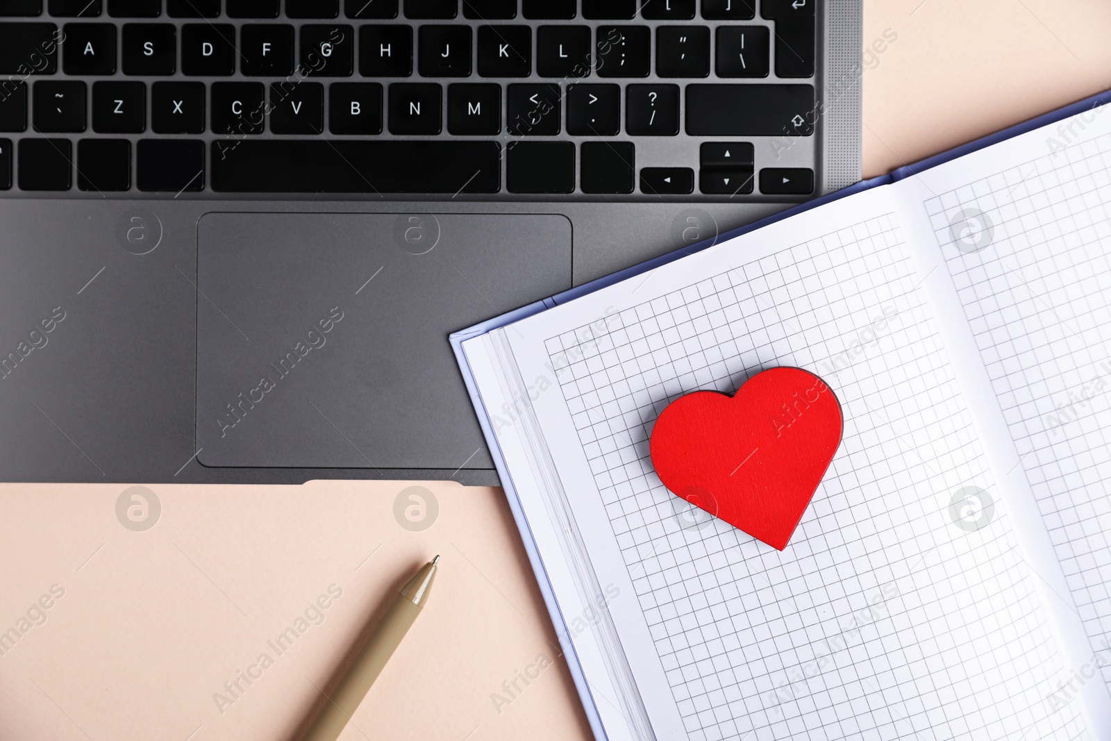 Online dating site. Laptop, notebook, red heart and pen on beige background, flat lay Photo of Online dating site. Laptop, notebook, red heart and pen on beige background, flat lay