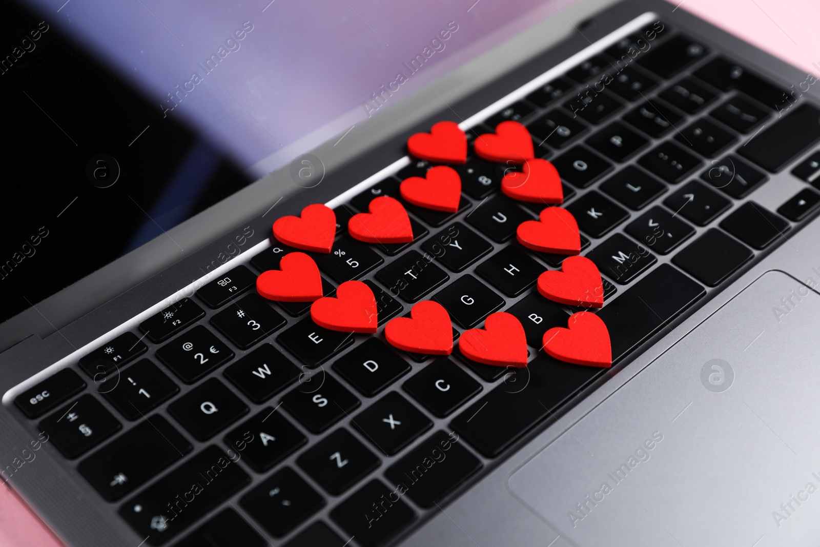 Photo of Online dating site. Many red hearts on laptop, closeup