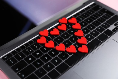 Photo of Online dating site. Many red hearts on laptop, closeup