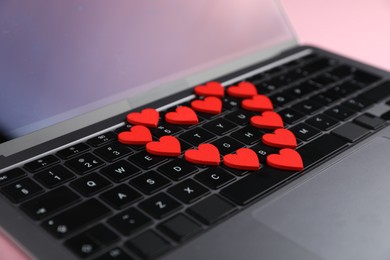 Photo of Online dating site. Many red hearts on laptop, closeup