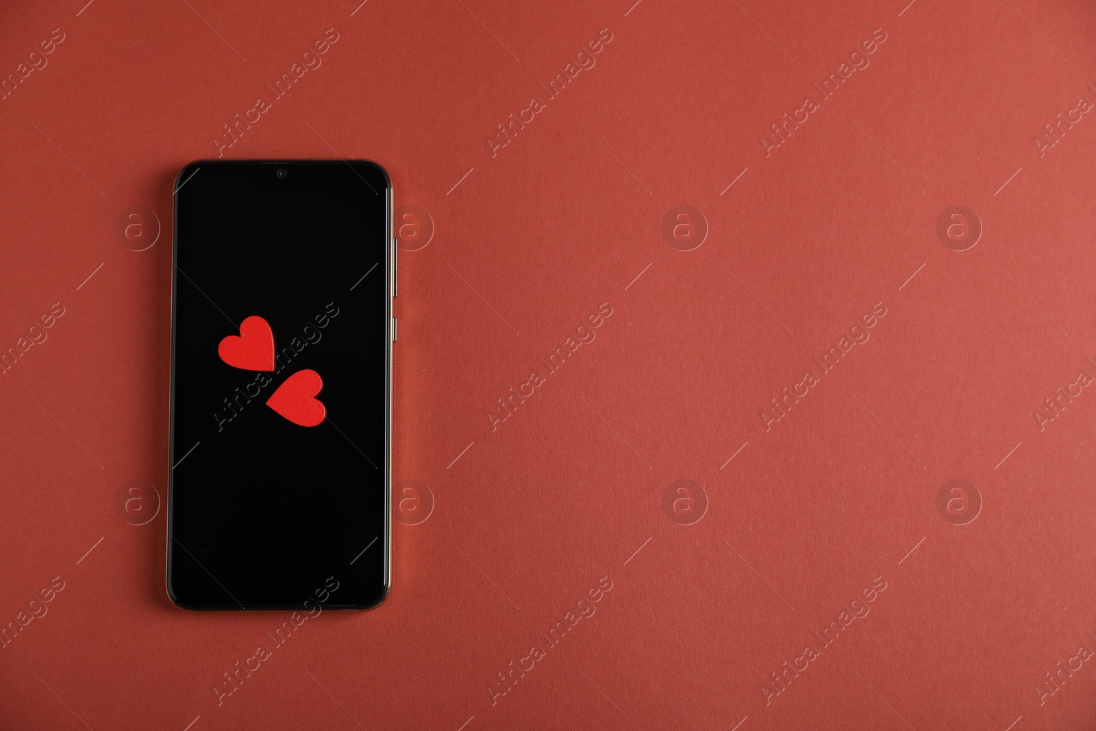 Online dating site. Smartphone and hearts on red-brown background, top view. Space for text Photo of Online dating site. Smartphone and hearts on red-brown background, top view. Space for text