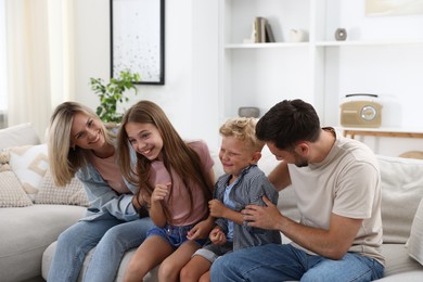 Photo of Happy family having fun on sofa at home