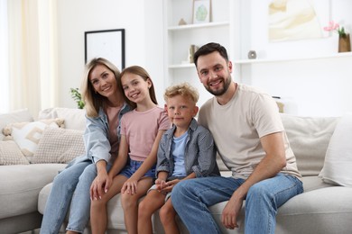 Photo of Happy family posing on sofa at home