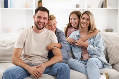 Photo of Happy family posing on sofa at home
