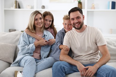Photo of Happy family posing on sofa at home