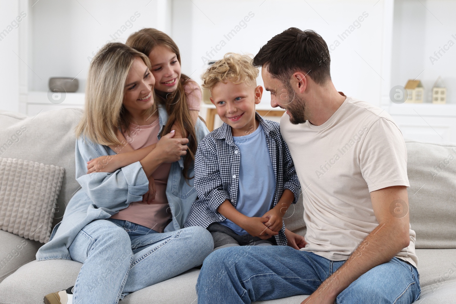 Photo of Happy family sitting on sofa at home
