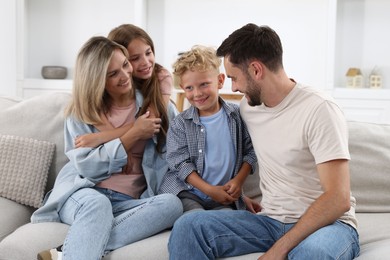 Photo of Happy family sitting on sofa at home
